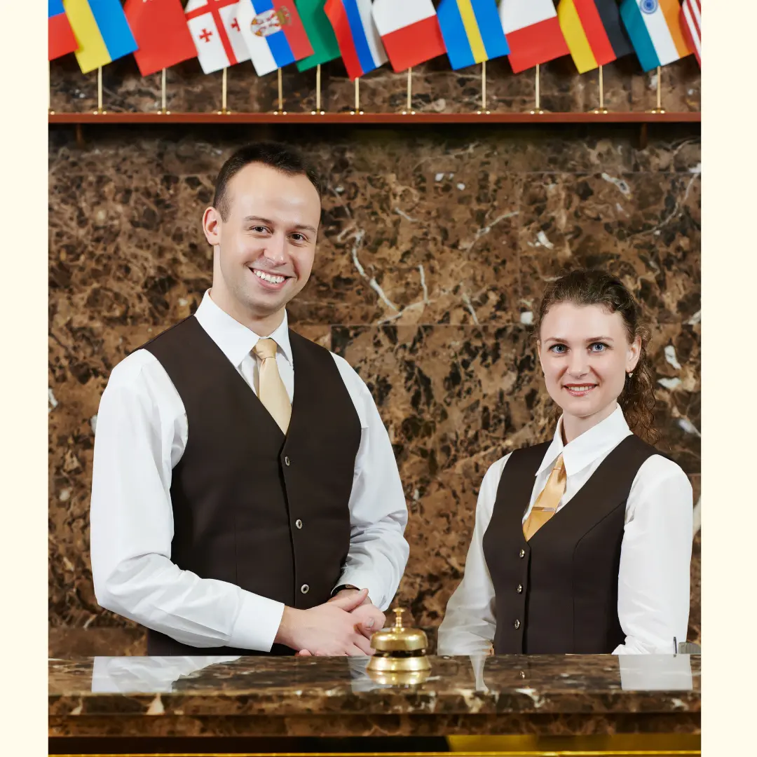 Hotel reception staff wearing coordinated professional uniforms, representing front-of-house hospitality service.