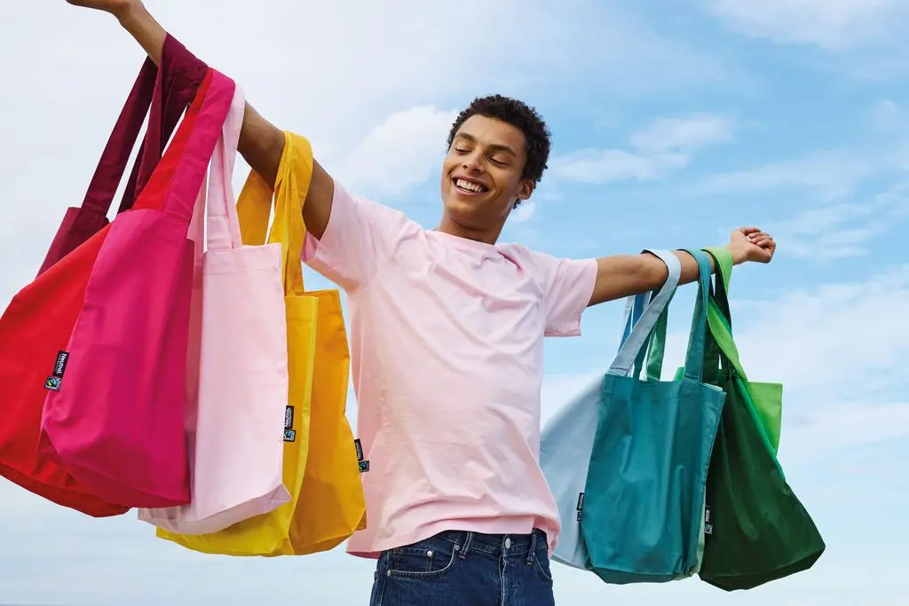 Fairtrade Bags on the arms of a person wearing  a fairtrade T-shirt