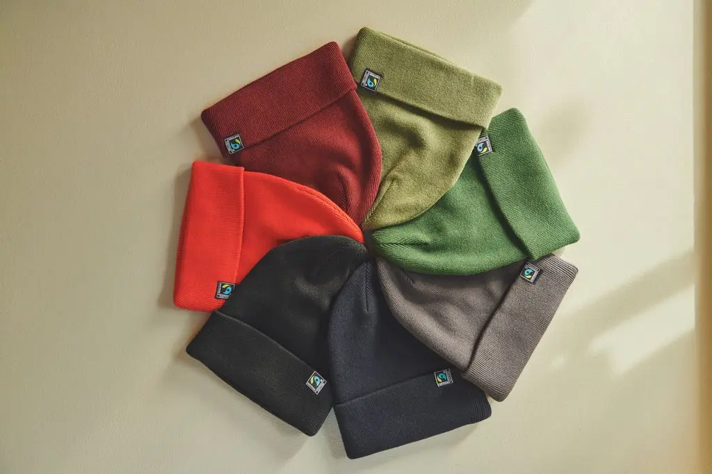 a selection of fairtrade beanies in seven different colours